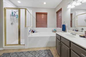 Bathroom with vanity, a bath, a stall shower, and recessed lighting