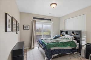 Bedroom featuring access to exterior and light wood-style flooring