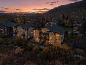 Back of house featuring a fenced backyard, a balcony, a chimney, and a mountain view