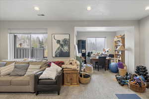 Carpeted living room featuring recessed lighting and a desk