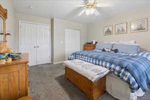 Bedroom featuring multiple closets, a ceiling fan, and carpet flooring