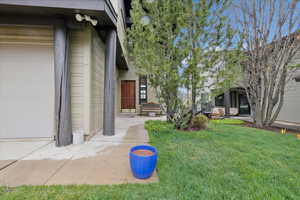 Property entrance with a yard, a surveillance system, and a garage
