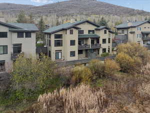 Rear view of property with a mountain view and a balcony