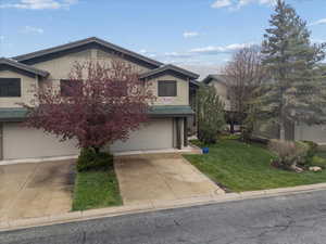 View of front of house with a front lawn, driveway, and an attached garage