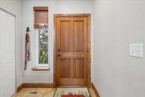 Foyer entrance featuring a textured wall and light tile patterned floors