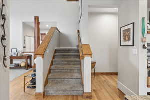 Stairway with wood finished floors and recessed lighting