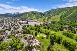 Aerial perspective showcasing a mountain community with ski slopes, a golf course, and residential areas