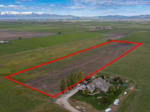 Aerial view of sparsely populated area with property parcel outlined and mountains