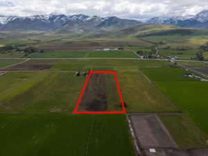 Overview of rural landscape with property parcel outlined and a mountainous background