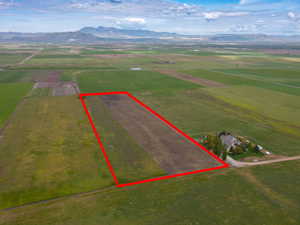 View of rural area featuring extensive farmland, property boundaries highlighted, and a mountainous background