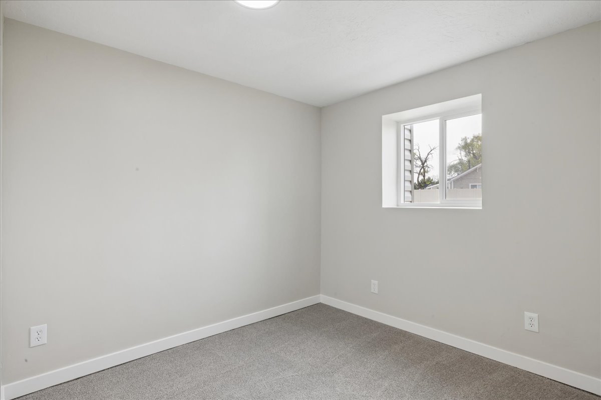 Empty room with baseboards and light colored carpet