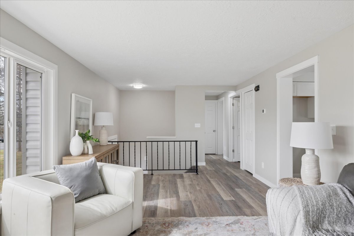 Sitting room with light wood-style flooring and an upstairs landing