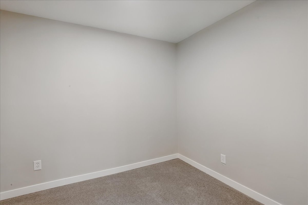 Carpeted empty room featuring baseboards