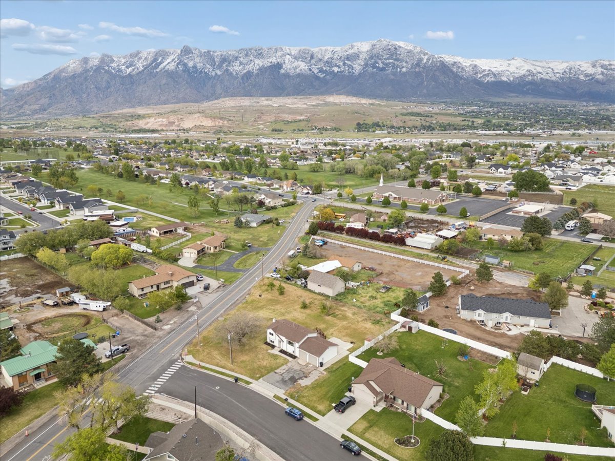Aerial view of property and surrounding area with nearby suburban area and mountains