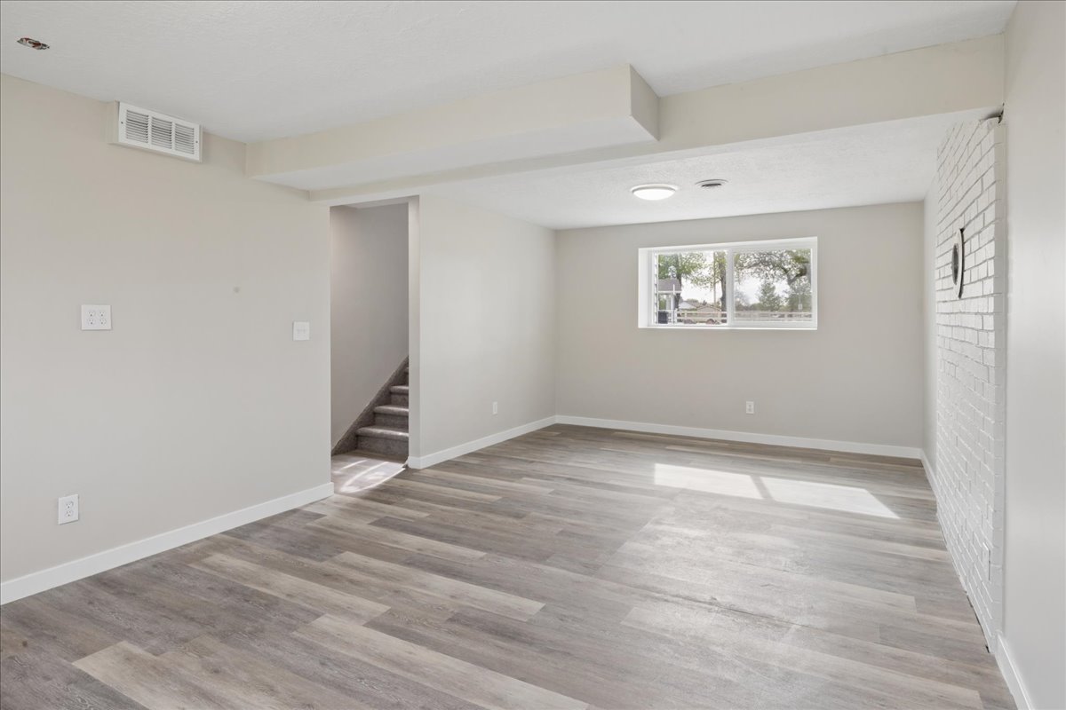 Basement with light wood-style flooring and baseboards