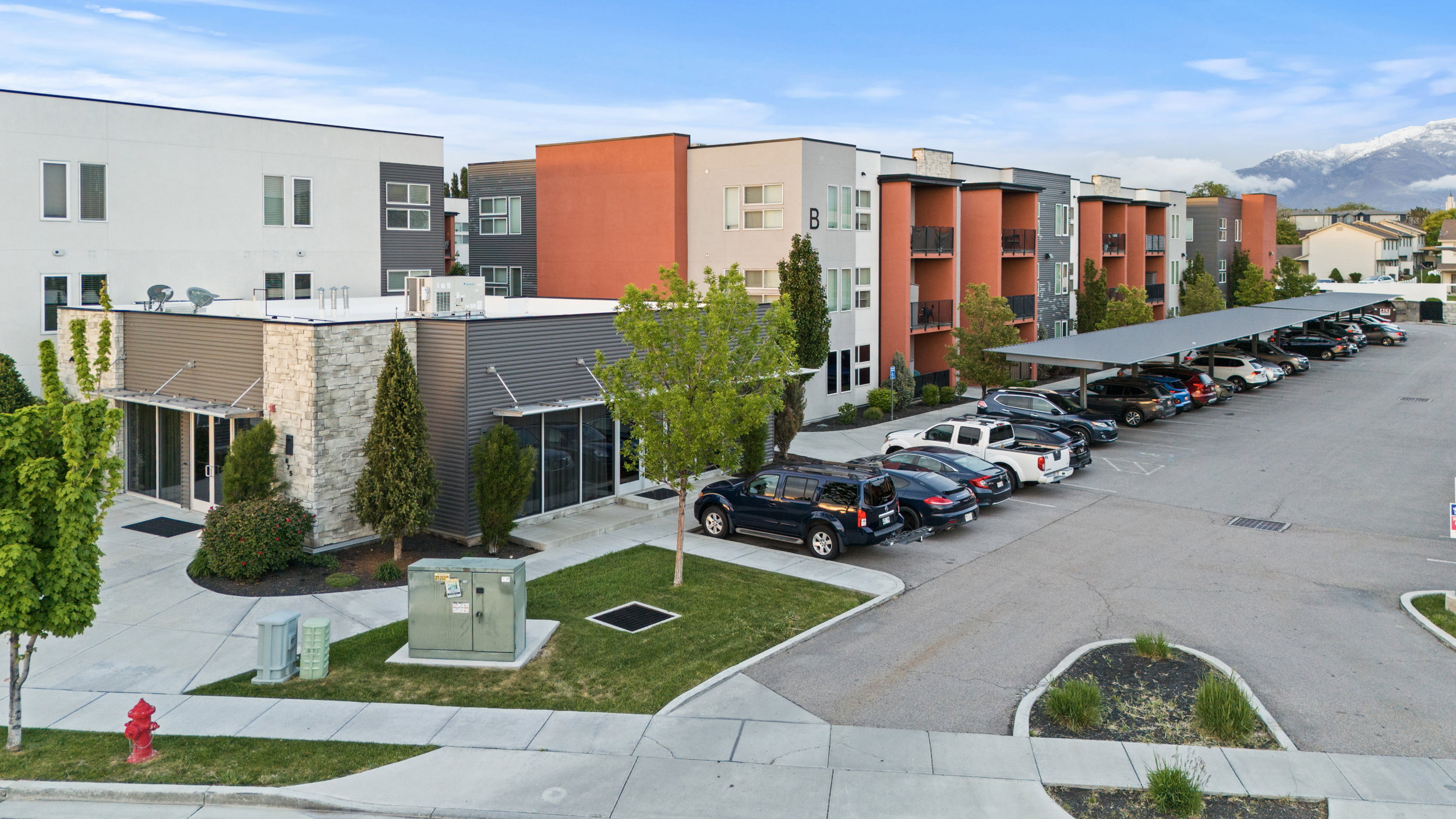 View of apartment building / complex featuring uncovered parking