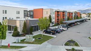 View of apartment building / complex featuring uncovered parking