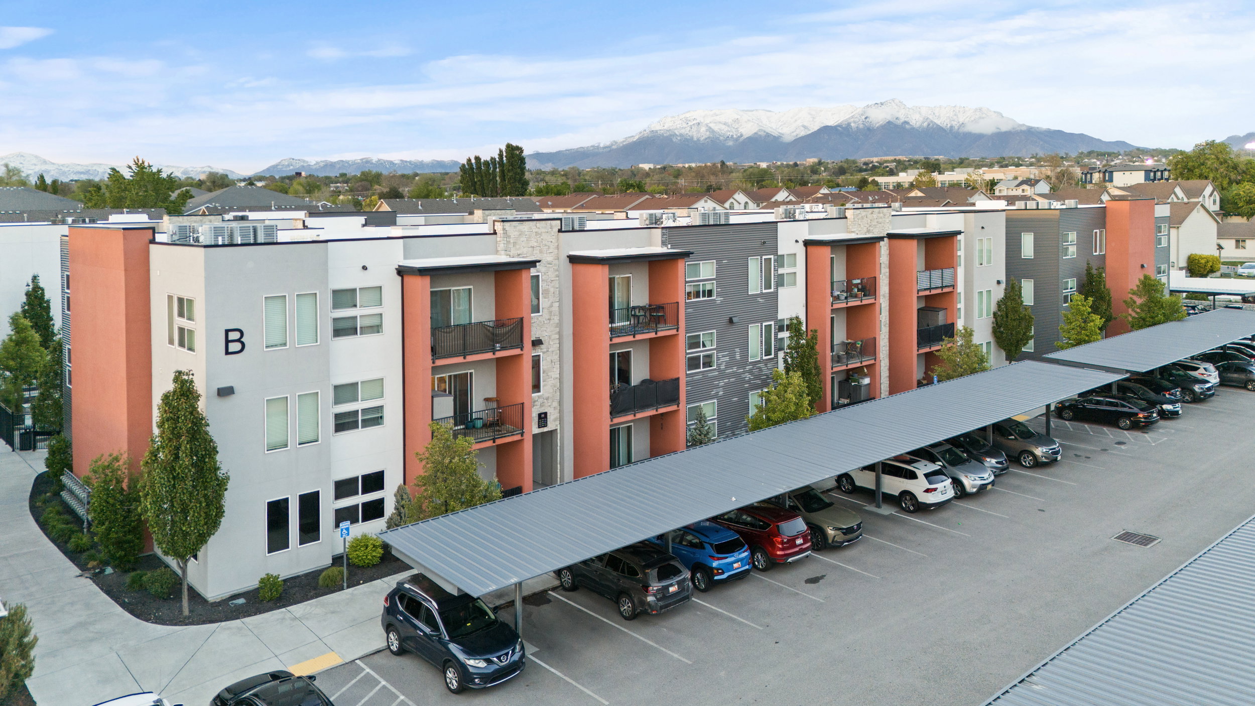 View of apartment building / complex featuring covered parking and a mountain view