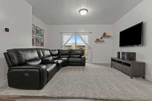 Living room featuring light carpet and a textured ceiling