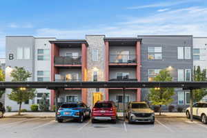 View of apartment building / complex with covered parking