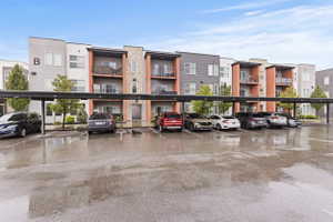 View of apartment building / complex with covered parking