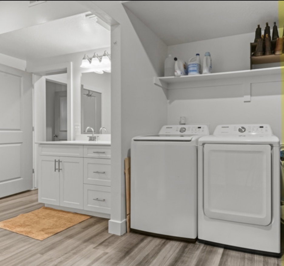 Laundry area featuring light wood-type flooring and washer and clothes dryer