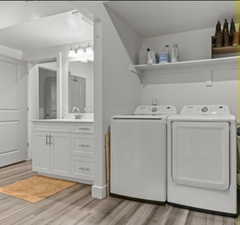 Laundry area featuring light wood-type flooring and washer and clothes dryer
