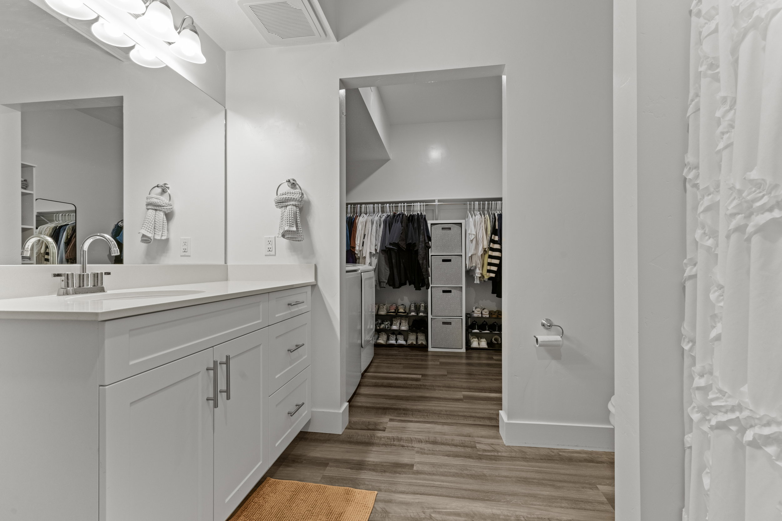 Bathroom with vanity, a spacious closet, dark wood finished floors, and curtained shower
