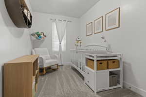 Bedroom with a crib and light carpet