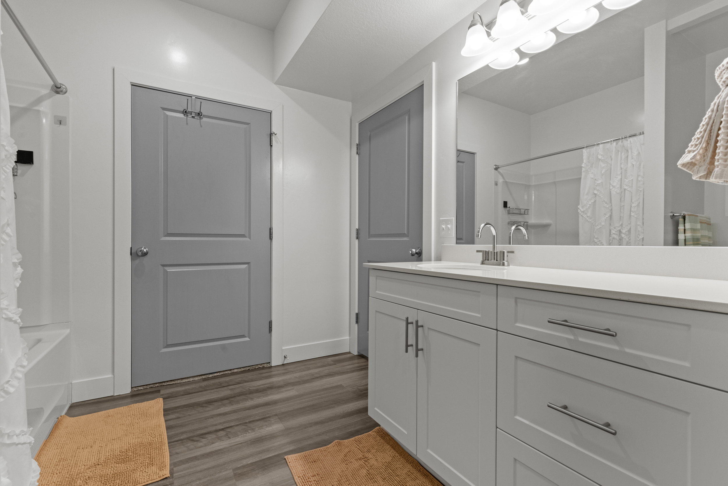 Full bathroom with vanity, dark wood-style flooring, and shower / bathtub combination with curtain
