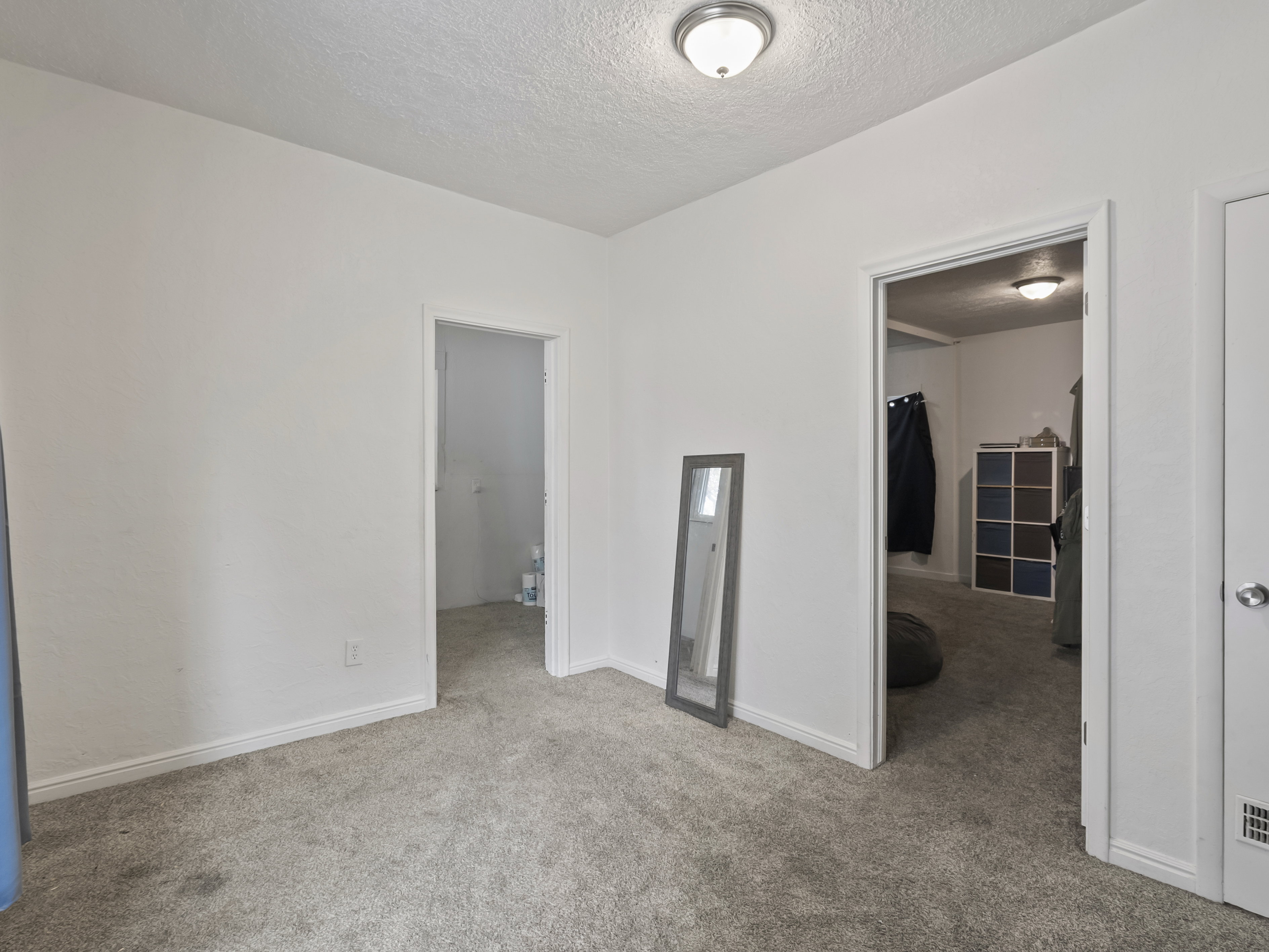 Unfurnished bedroom featuring light colored carpet and a textured ceiling