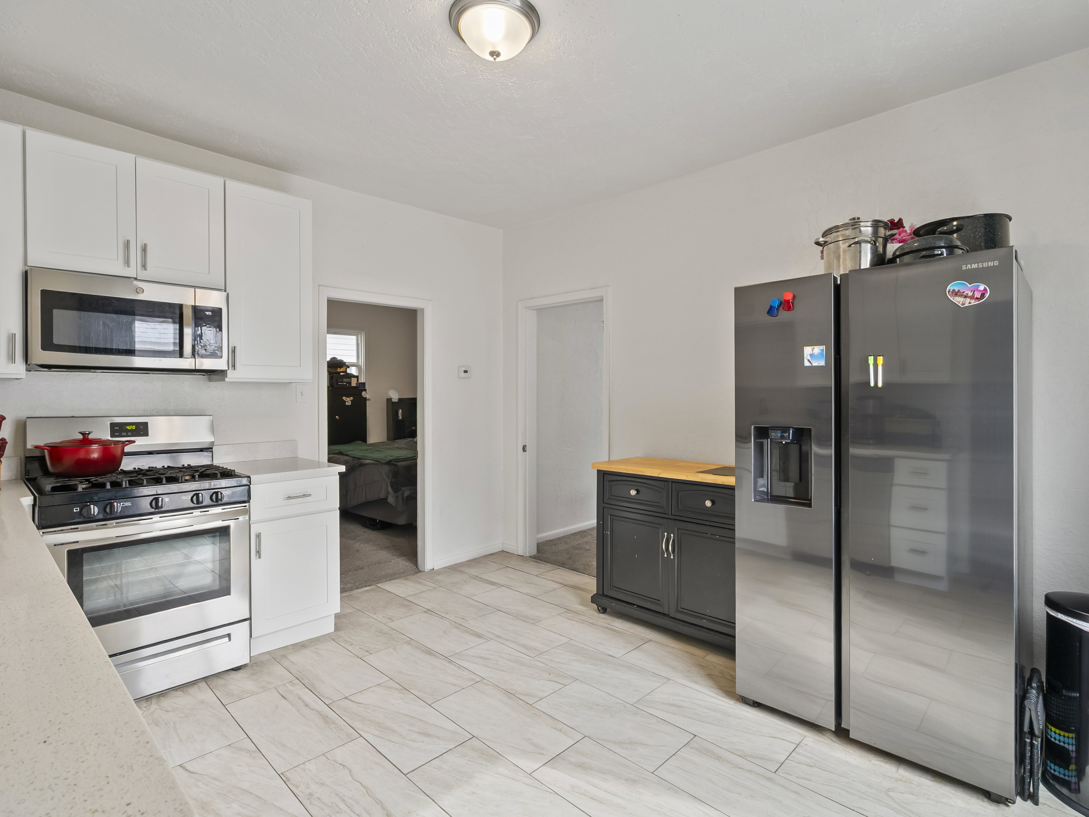 Kitchen with stainless steel appliances, wooden counters, and white cabinetry