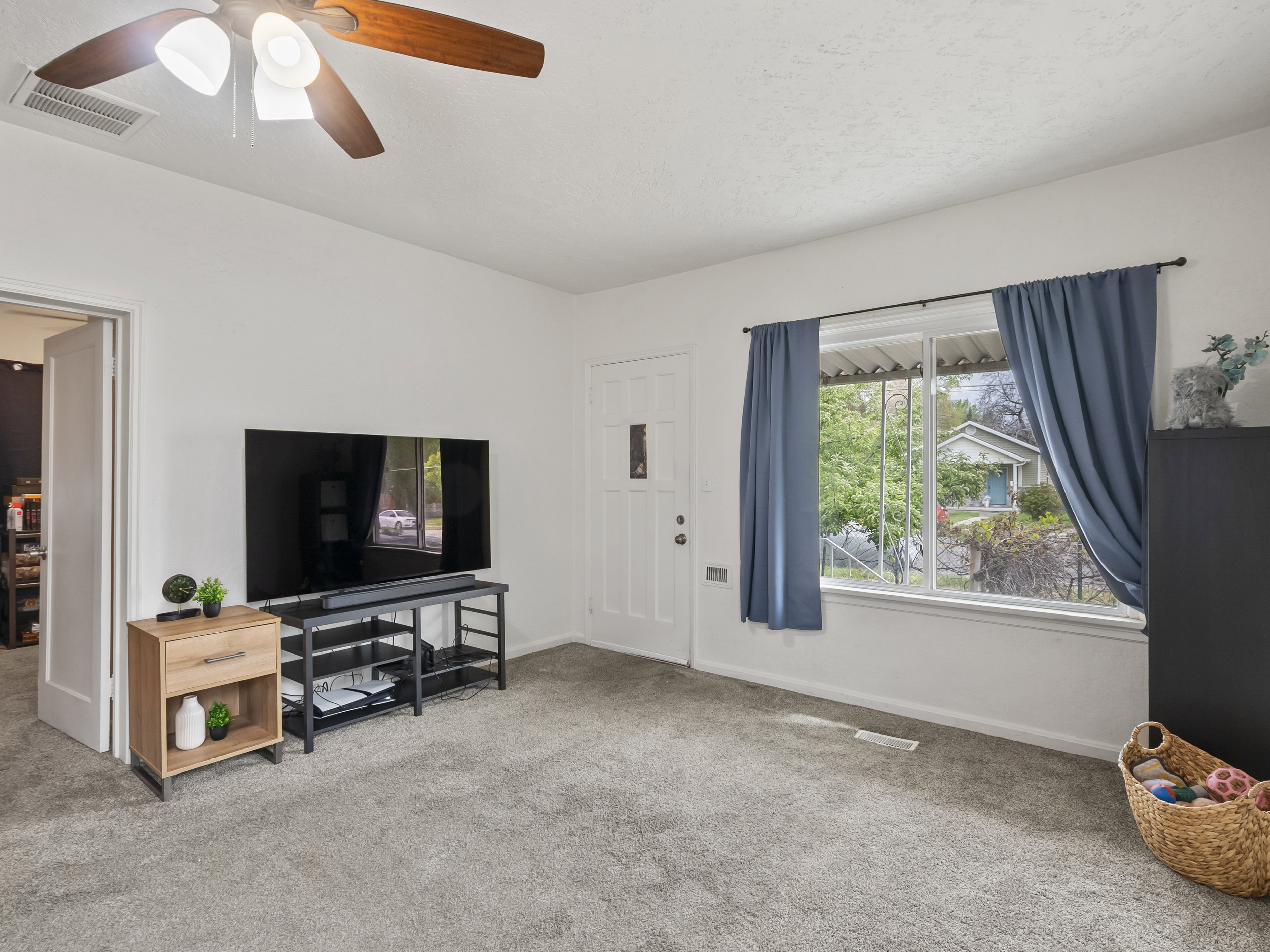 Living area featuring carpet flooring and ceiling fan