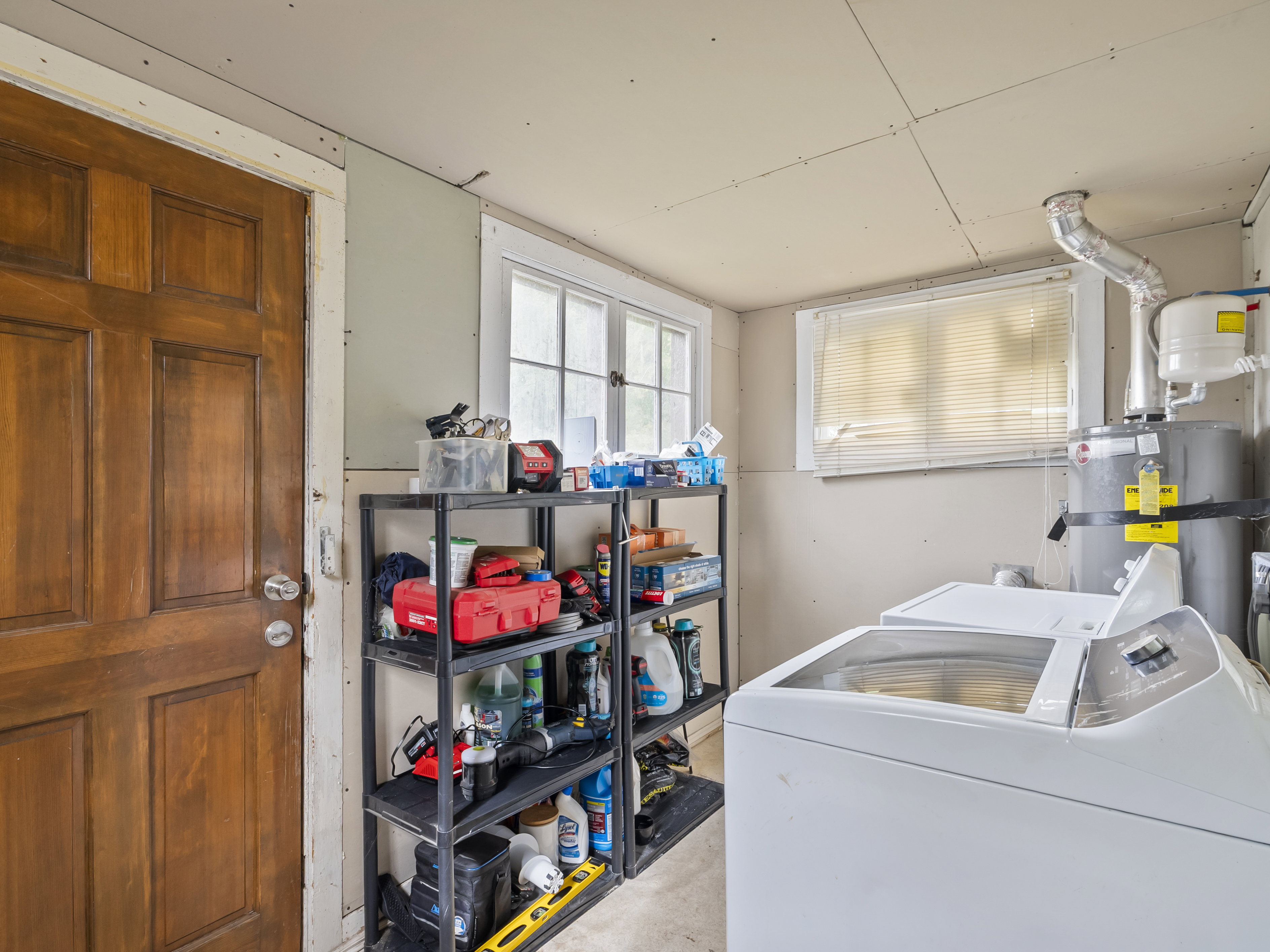 Laundry area featuring strapped water heater and separate washer and dryer