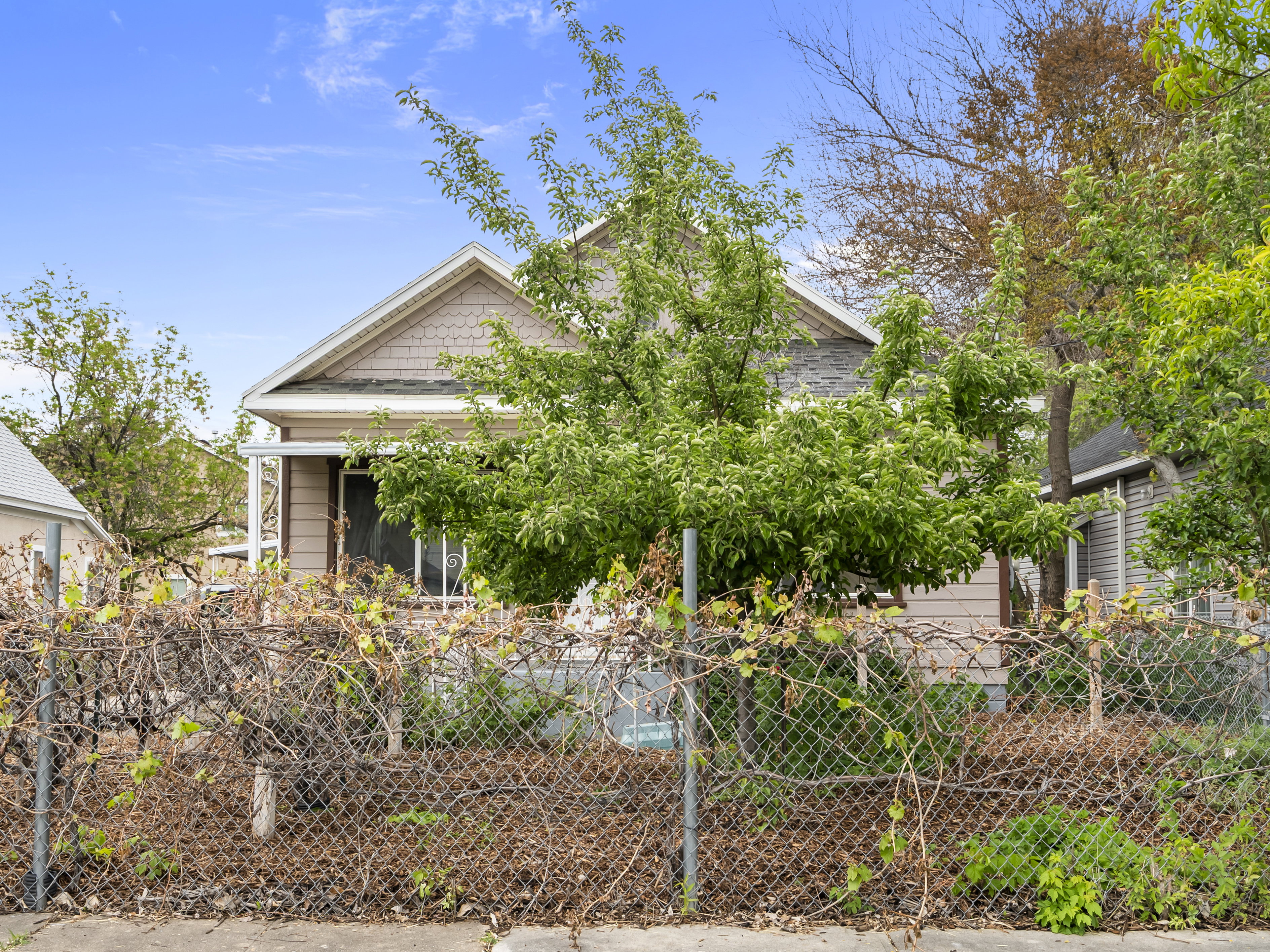 View of front of home featuring a fenced front yard and roof with shingles