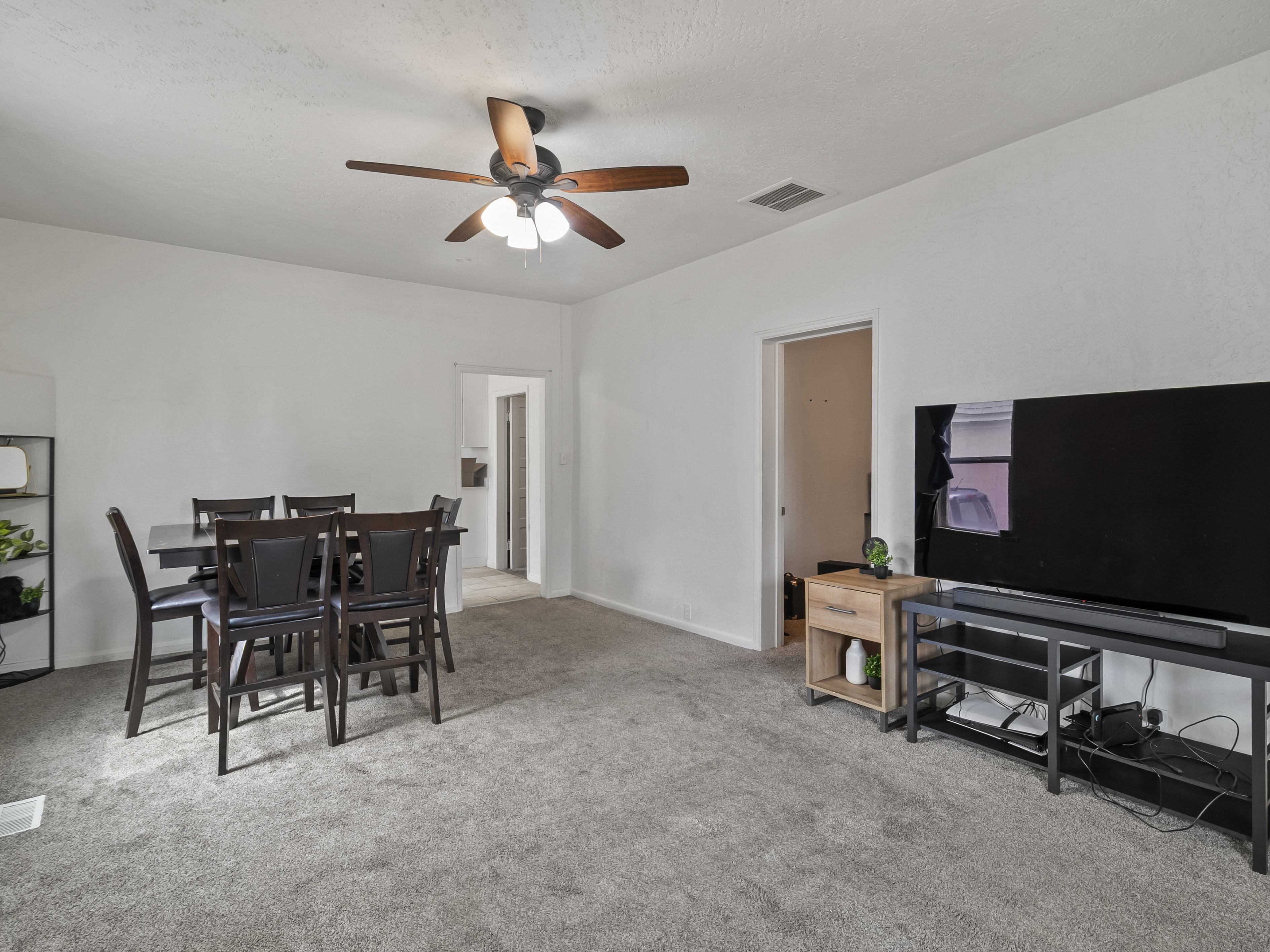 Dining space with light carpet and a ceiling fan