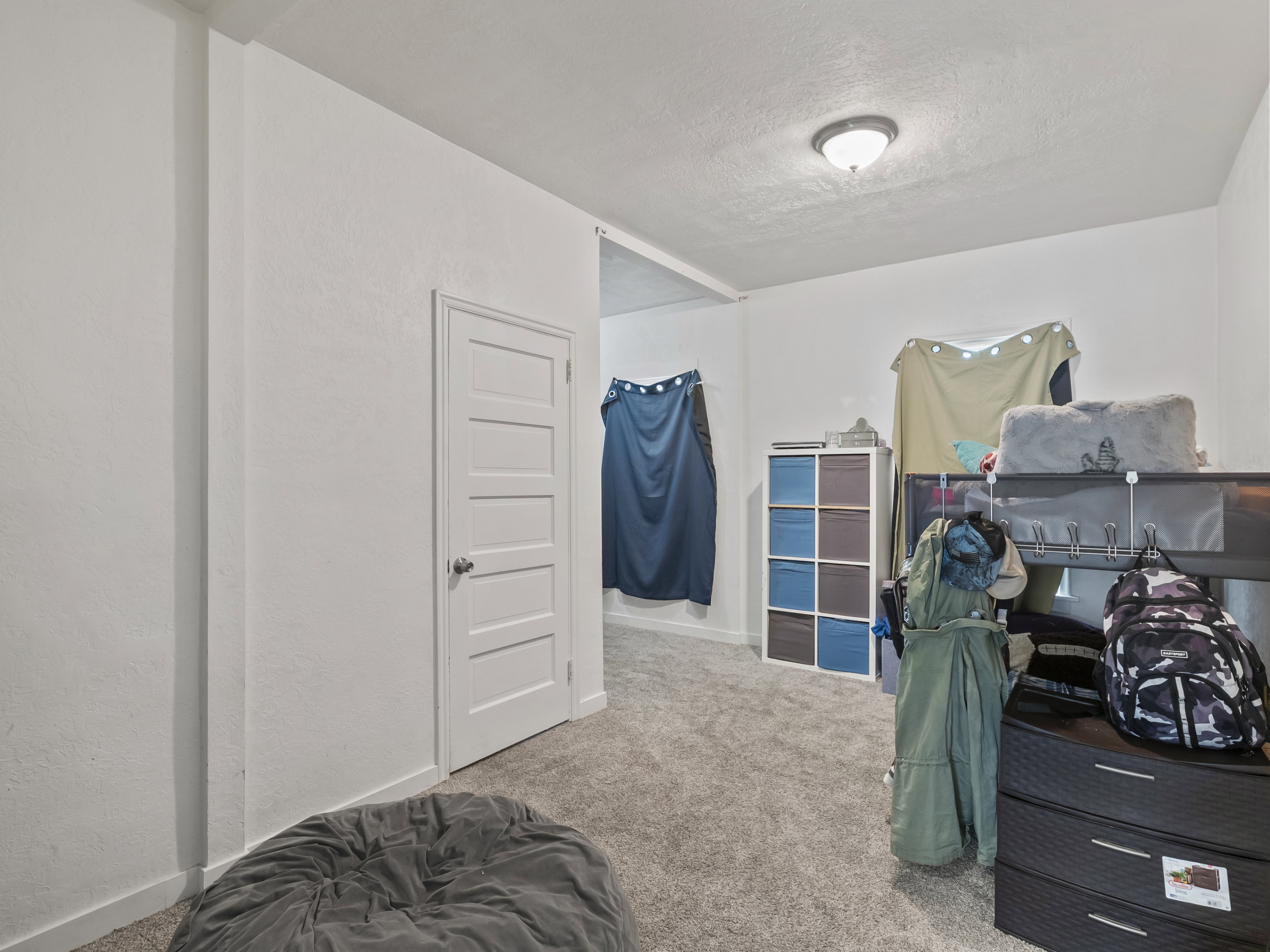 Bedroom featuring carpet flooring, a textured ceiling, and a textured wall