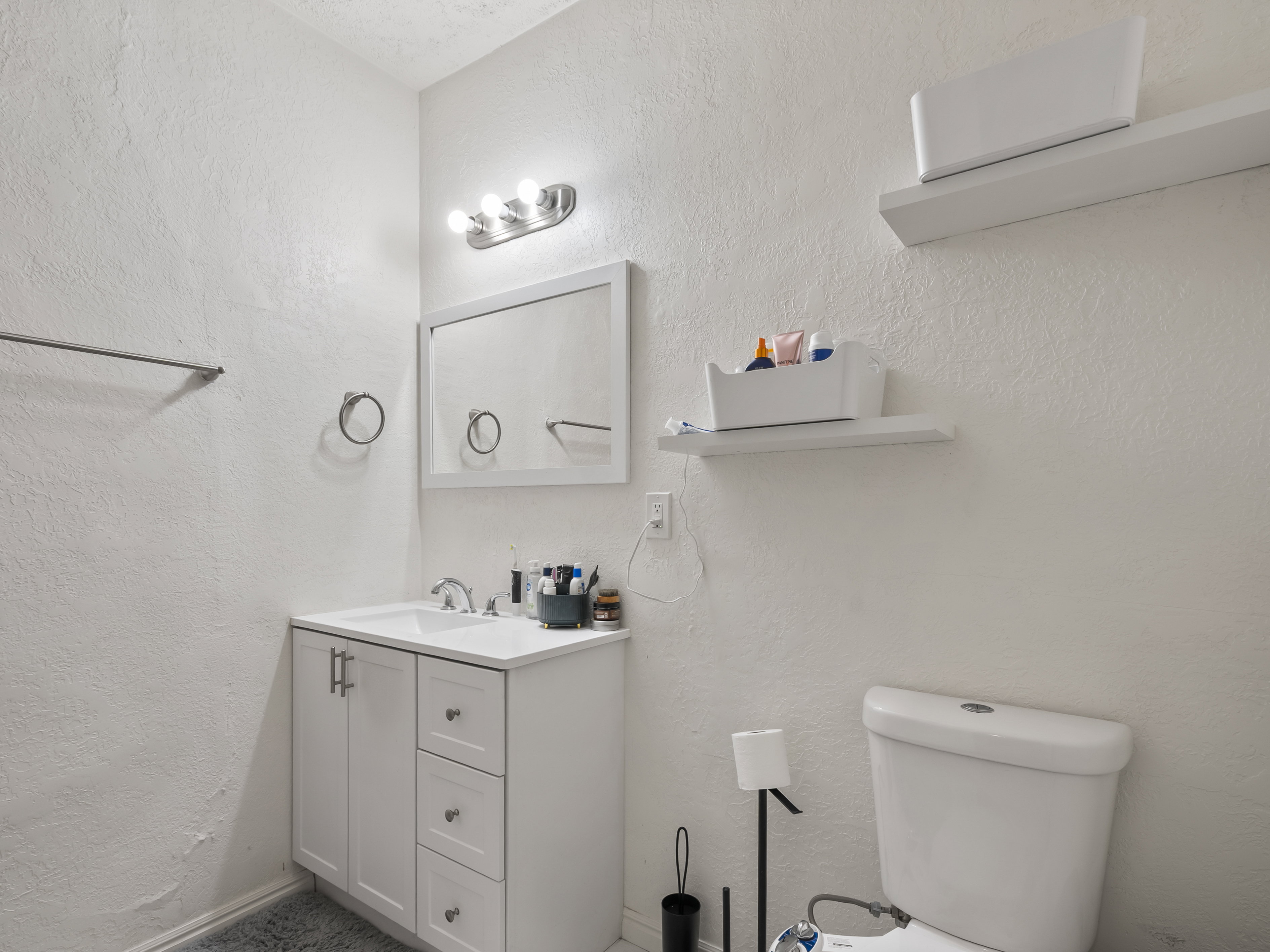 Bathroom featuring vanity and a textured wall