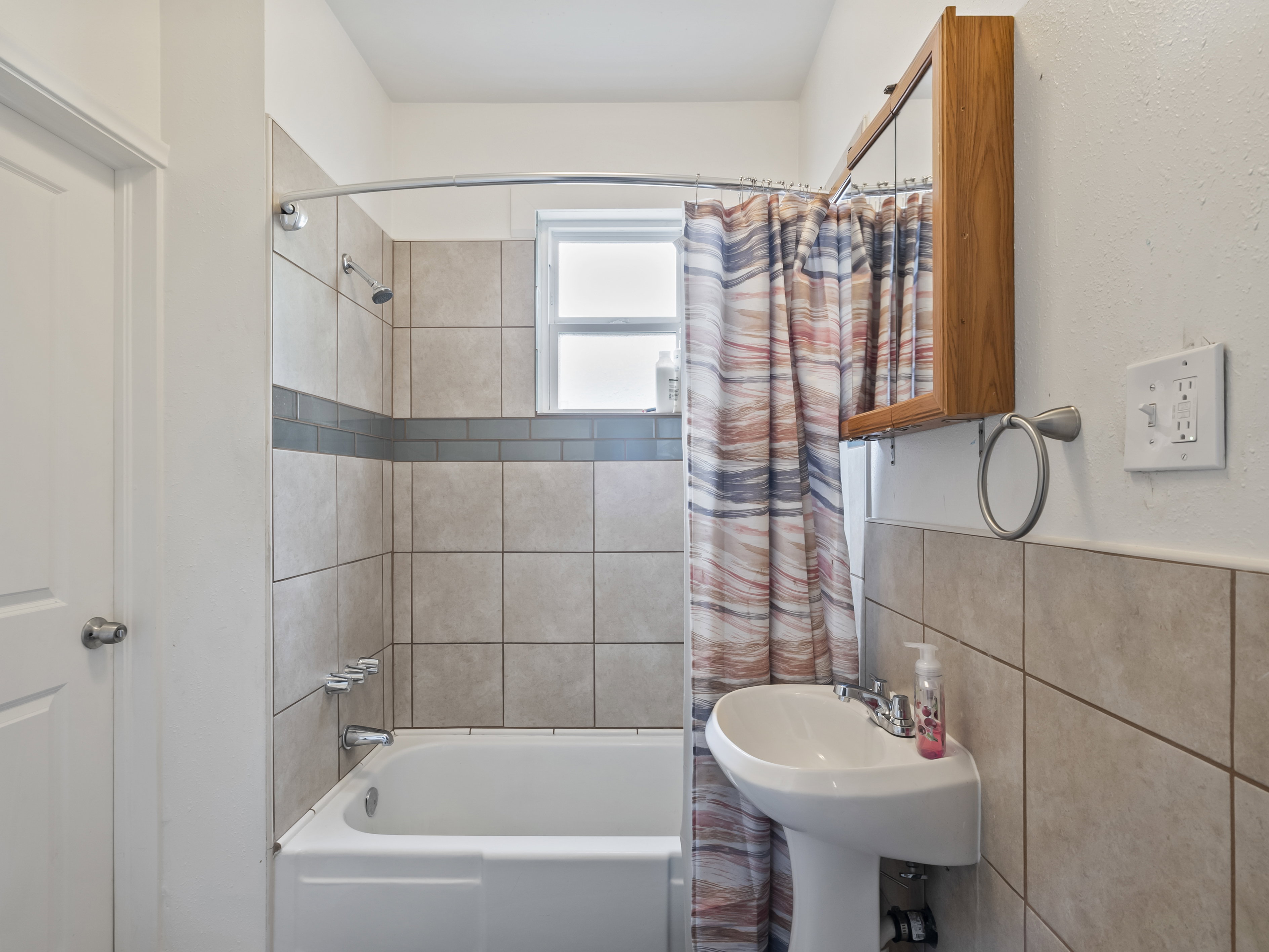 Bathroom with shower / bath combo with shower curtain and tile walls