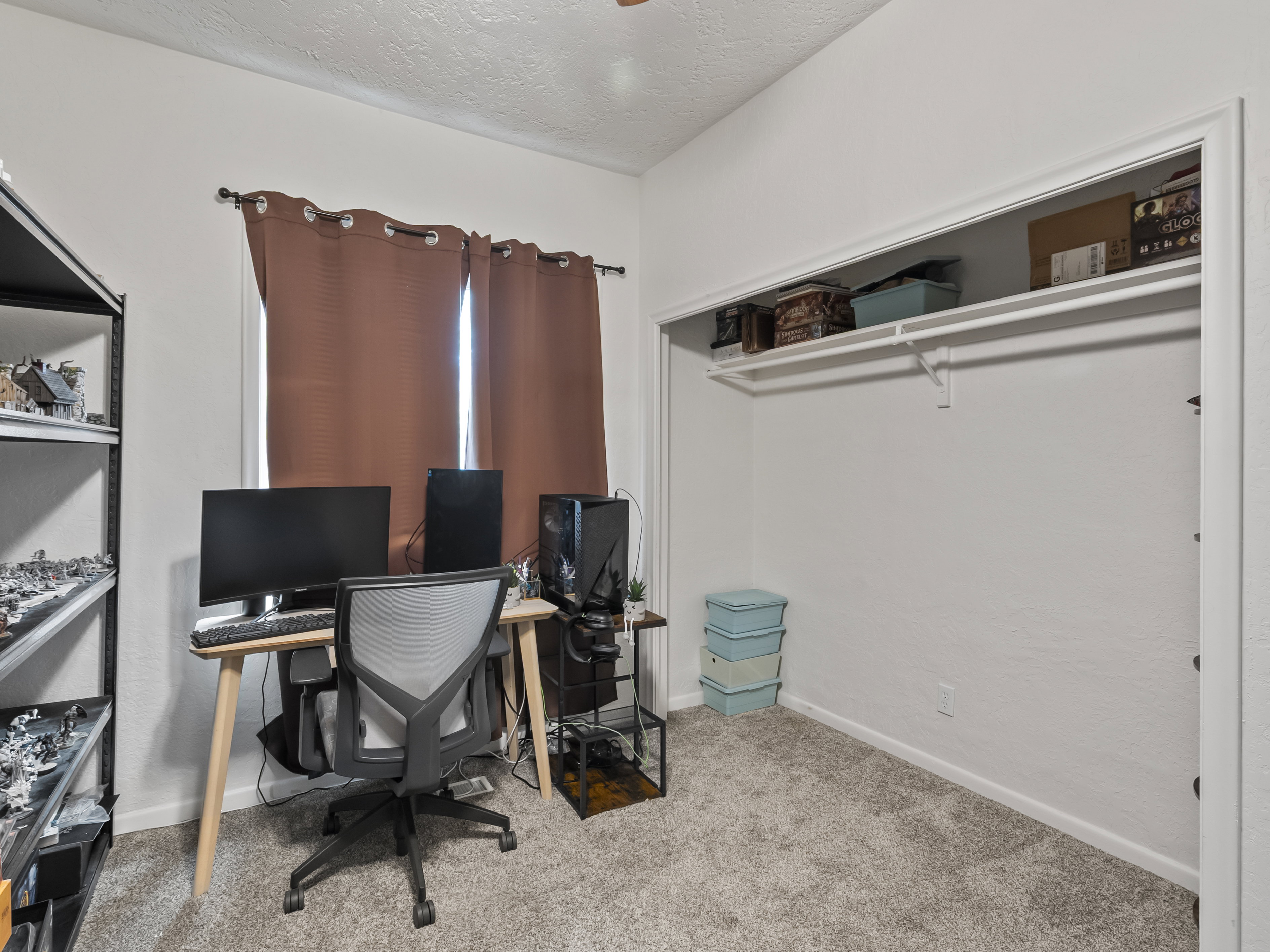 Office area with a textured ceiling and light colored carpet