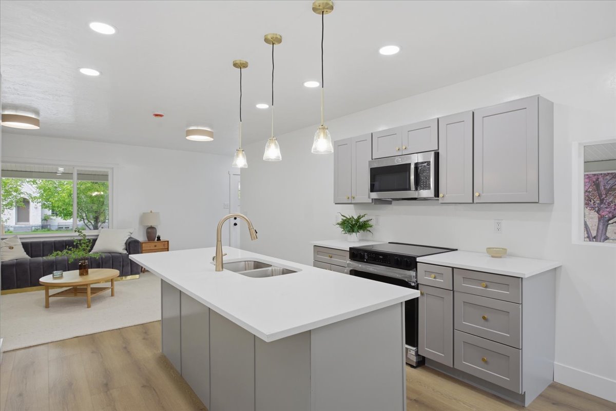 Kitchen featuring gray cabinetry, light wood-type flooring, and electric stove