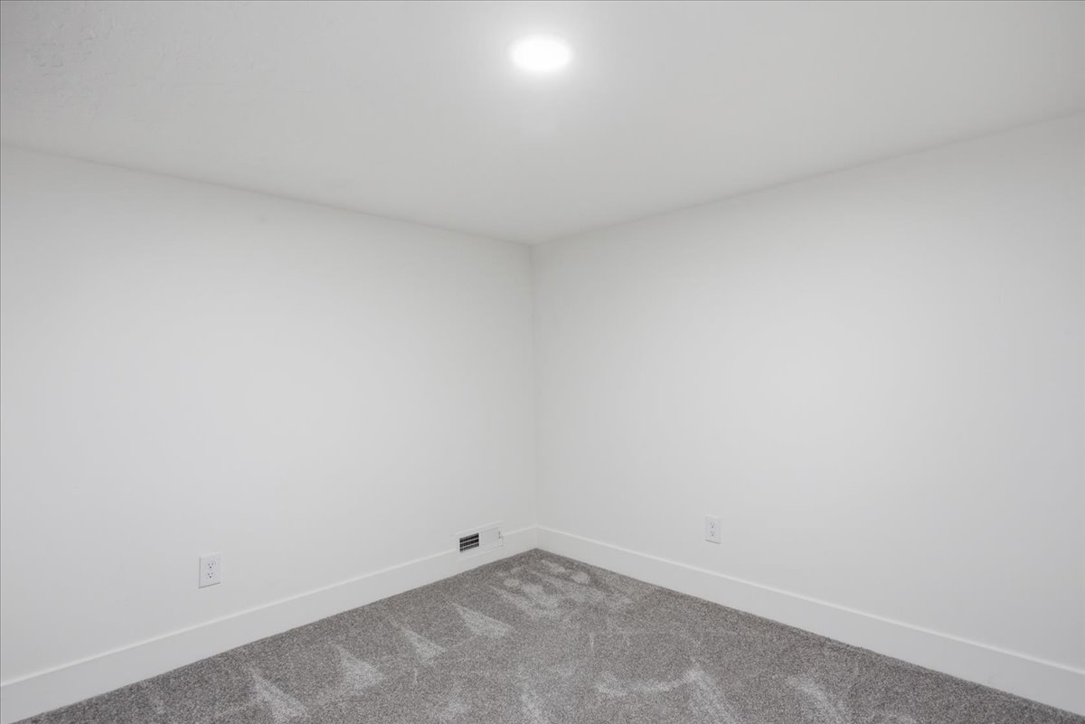 Carpeted spare room featuring baseboards