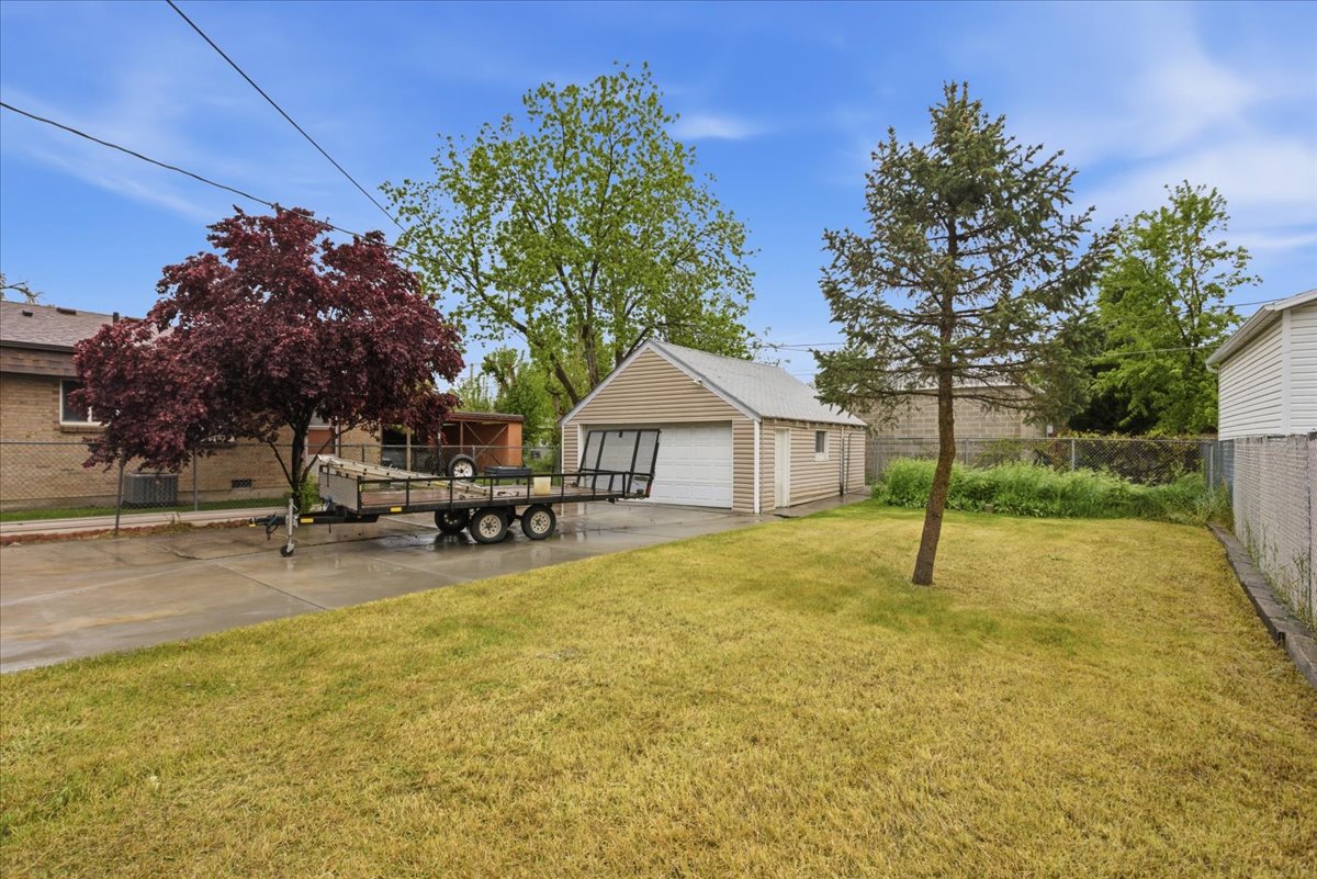 View of yard featuring a detached garage and an outbuilding