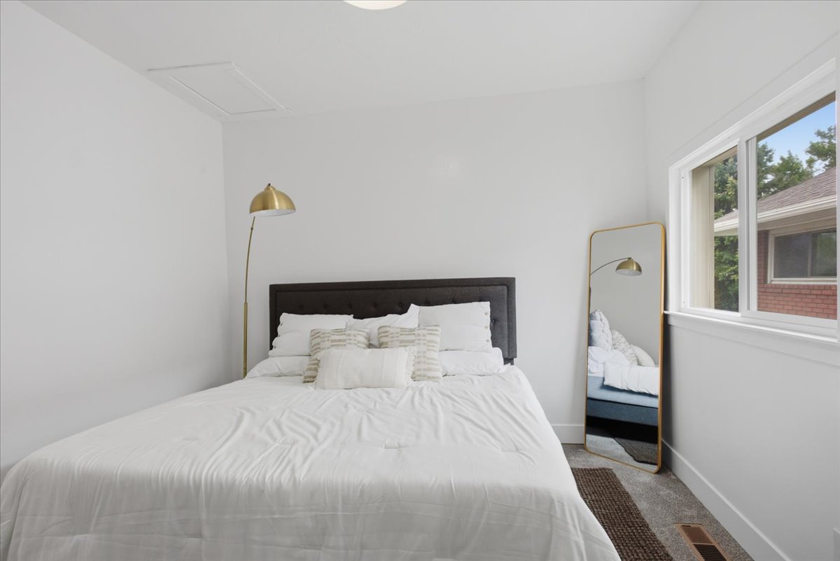 Carpeted bedroom featuring baseboards and attic access