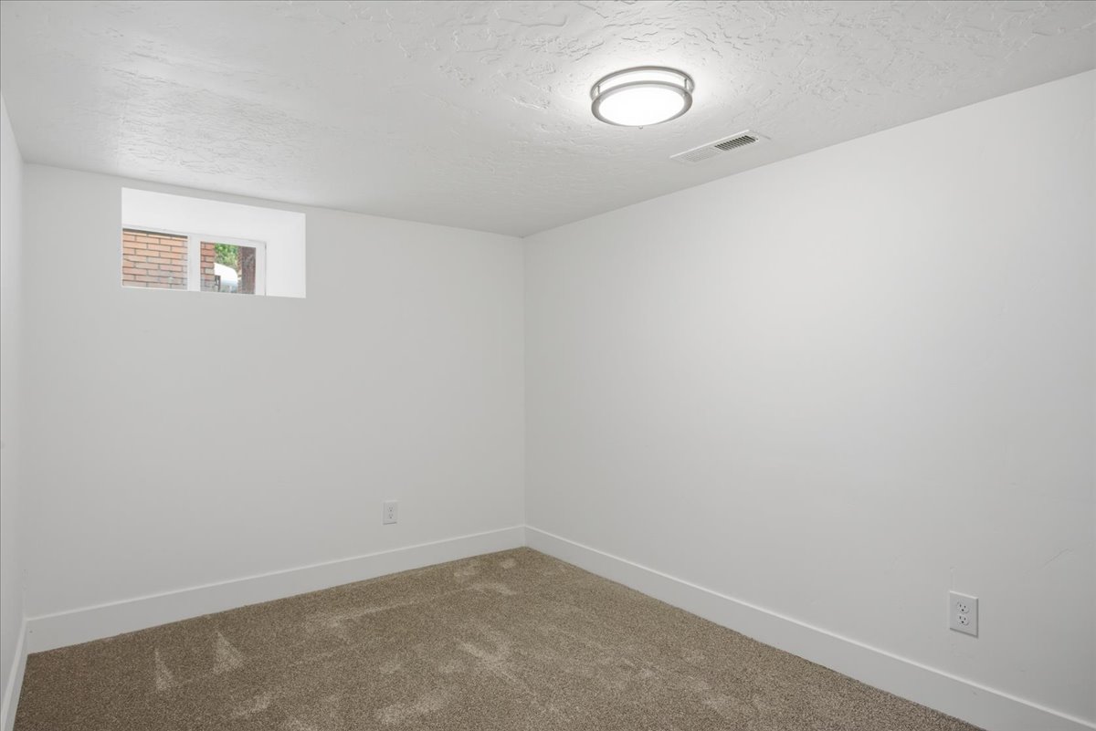 Spare room with a textured ceiling and carpet