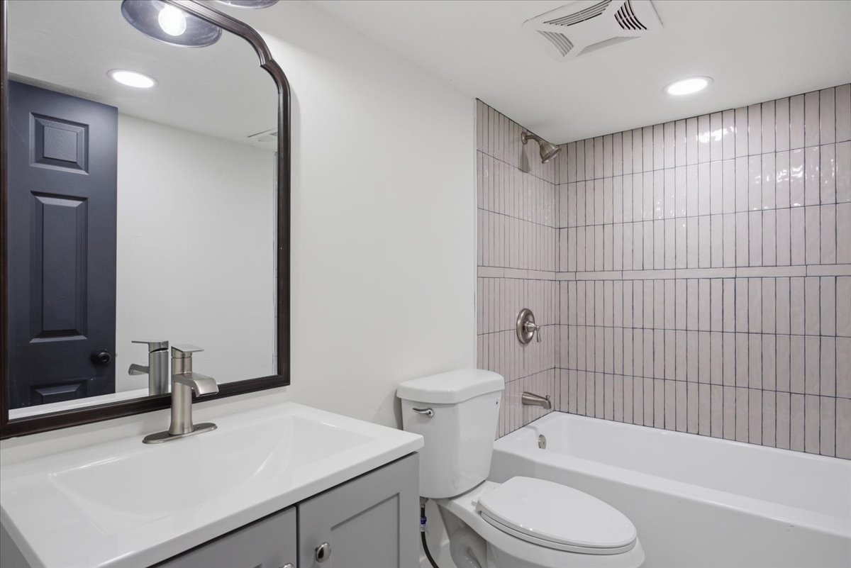 Full bath with vanity, shower / washtub combination, and recessed lighting