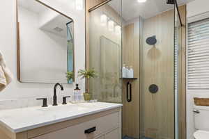 Bathroom featuring vanity and a shower stall