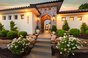 View of exterior entry with stone siding and stucco siding