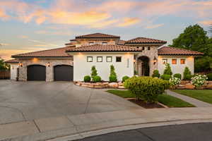 Mediterranean / spanish house featuring stone siding, an attached garage, concrete driveway, and stucco siding