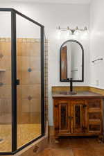 Full bathroom featuring vanity, a stall shower, and tile patterned floors